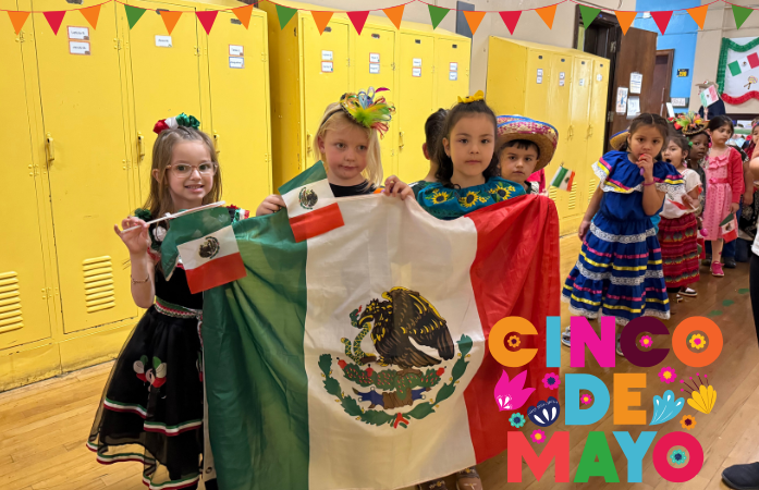  3 students holding up a mexican flag in the hallway